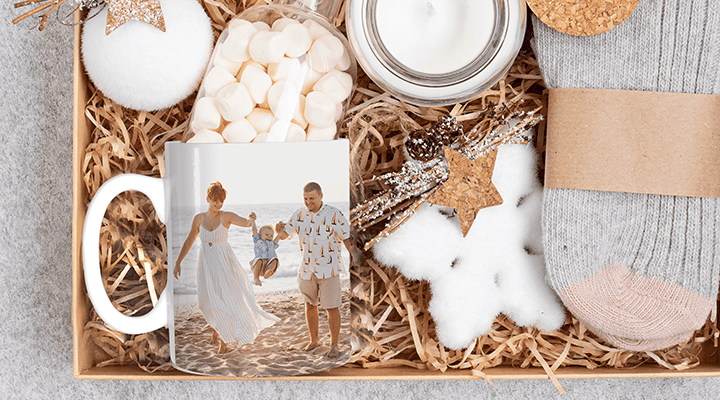 Gift hamper with a personalised photo mug showing a happy family playing with their toddler, and marshmallows and a pair of socks