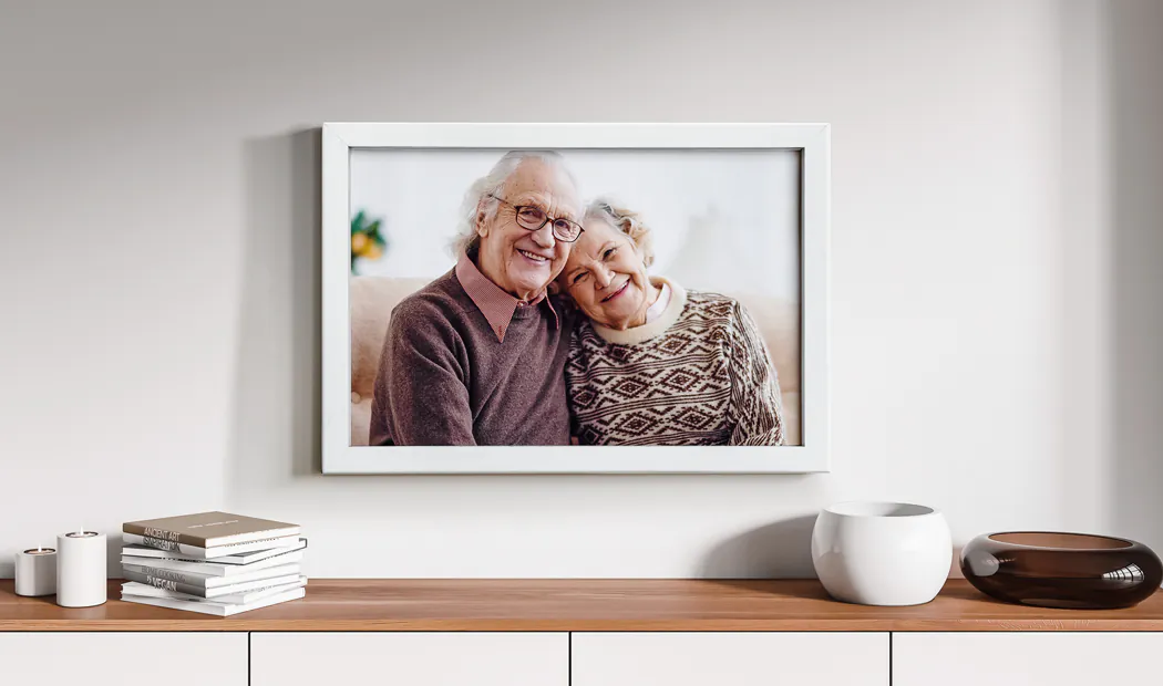 A framed photograph of grandparents on a sideboard