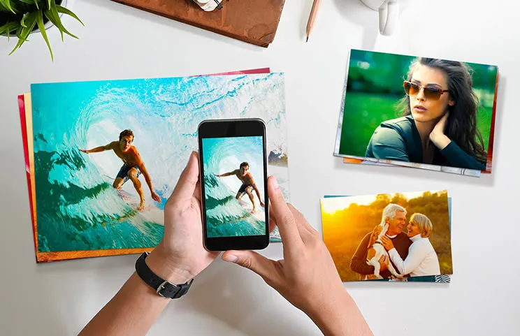 Small medium and large photo prints on table from mobile phone